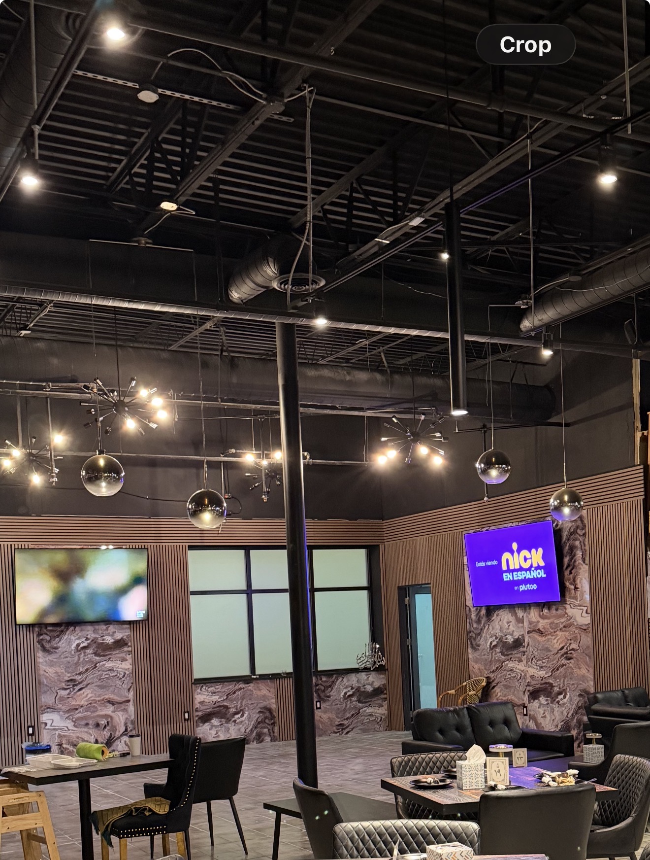 Completed commercial interior transformation with wood wall panels, lighting, and seating